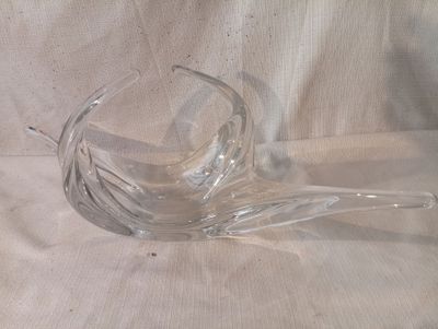 un saladier en verre transparent muni d'une poignée incurvée, posé sur une nappe blanche