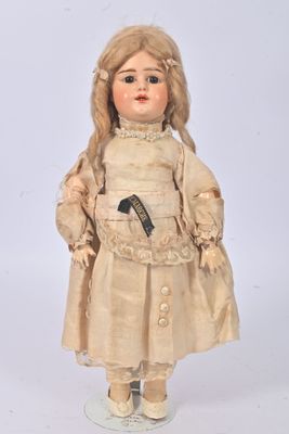 une poupée à l'ancienne aux cheveux blonds, vêtue d'une robe et de chaussures