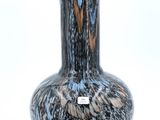 a black and blue vase sitting on a white surface