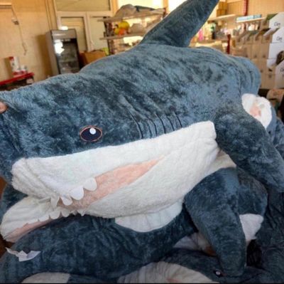 a large stuffed shark that is sitting on the floor