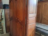 a wooden armoire in a room with a mattress on the floor