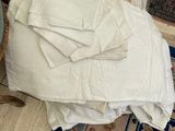 a pile of white towels on the floor next to a chair