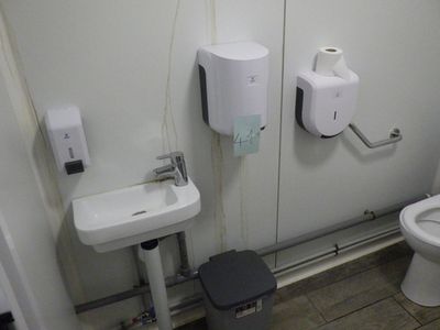 une salle de bains équipée de toilettes, d'un lavabo et d'un sèche-mains