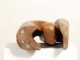 a wooden sculpture on a white pedestal with a white background