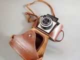 a brown leather camera case with a camera attached to it