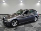 Une BMW Série 3 Touring de 2011 exposée dans un showroom au sol à damier