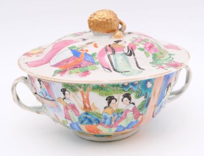 a bowl with a lid and a handle on a white surface