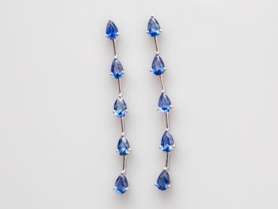 une paire de boucles d'oreilles en cristal bleu sur fond blanc