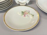 a plate with a flower design on it next to a stack of plates