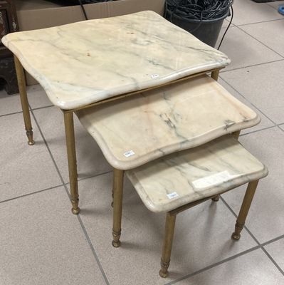three marble top nesting tables in a room with tile flooring