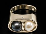 a close up of a ring with two pearls on it