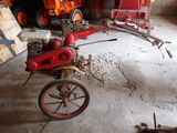 un petit tracteur équipé d'un petit moteur, garé dans un garage