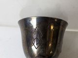 someone is holding a silver cup with a cross on it