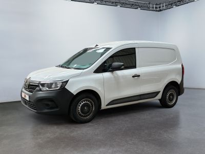La camionnette blanche est garée dans une grande pièce aux murs blancs.