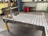 a metal table that has holes on it in a garage