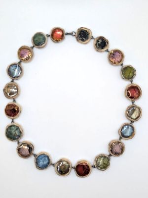 a close up of a necklace on a white surface