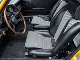 the interior of a yellow car with black leather seats and a steering wheel