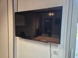 un téléviseur à écran plat fixé au mur d'une pièce