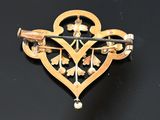 an image of a gold brooch with a cross on it