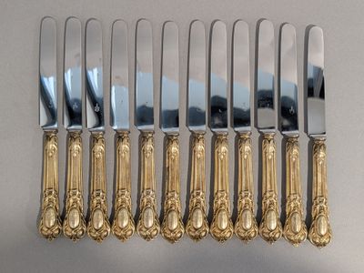cinq fourchettes et un couteau alignés sur une table
