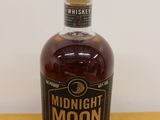 a bottle of whiskey sitting on a wooden table