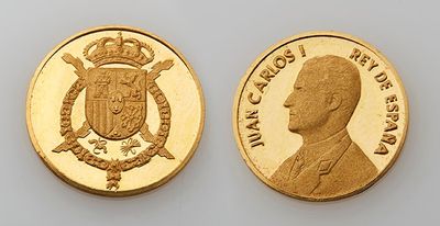 a close up of two gold coins on a white surface