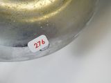 un vase en argent sur lequel est collé un autocollant