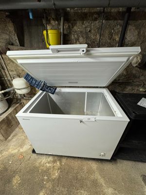 a white chest freezer sitting in a garage