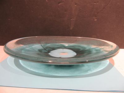 a glass bowl sitting on a plate on a table