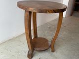 a small table with a wooden top on a concrete floor