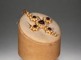 an image of a wooden box with a pair of earrings on top of it