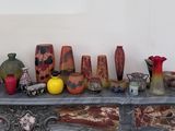 de nombreux vases de toutes sortes posés sur une table dans une pièce