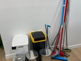 a lot of trash cans and brooms in the corner of the room