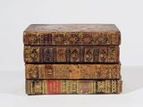 three books stacked on top of each other on a white surface