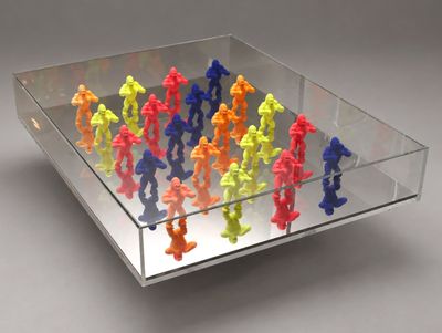 Des figurines en plastique aux couleurs vives sont disposées dans une vitrine transparente