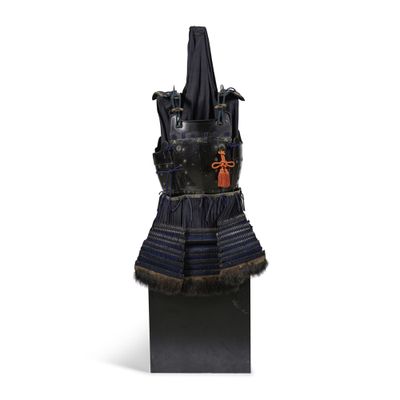une statue représentant une femme vêtue d'une robe noire ornée de fourrure