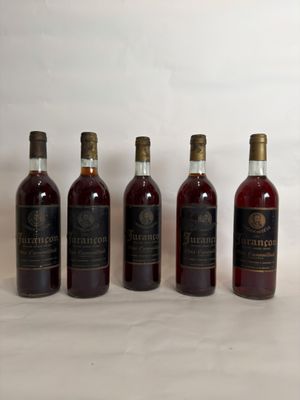 six bottles of wine are lined up on a white surface