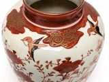 a vase with a bird design on it sitting on a table