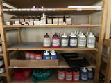 many cans of paint on the shelves in the room