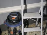 a vacuum and a chair in the corner of a room