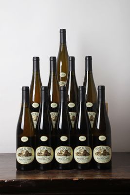 des bouteilles de vin posées sur une table devant un mur blanc