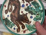 a person holding a plate with a horse on it