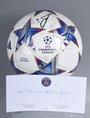 a soccer ball with a signed card on top of it