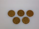four gold coins sitting on top of each other on a white surface