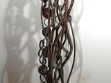 une sculpture en métal posée sur un socle en bois