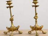 pair of antique brass candlesticks sitting on a wooden table