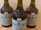 three bottles of wine sitting on top of a wooden table