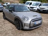 a silver mini cooper parked in a lot with other cars