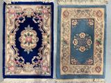 Deux tapis de couleurs et de tailles différentes sont accrochés au mur.