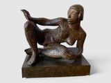 statue représentant une femme allongée sur le ventre sur un socle en bois